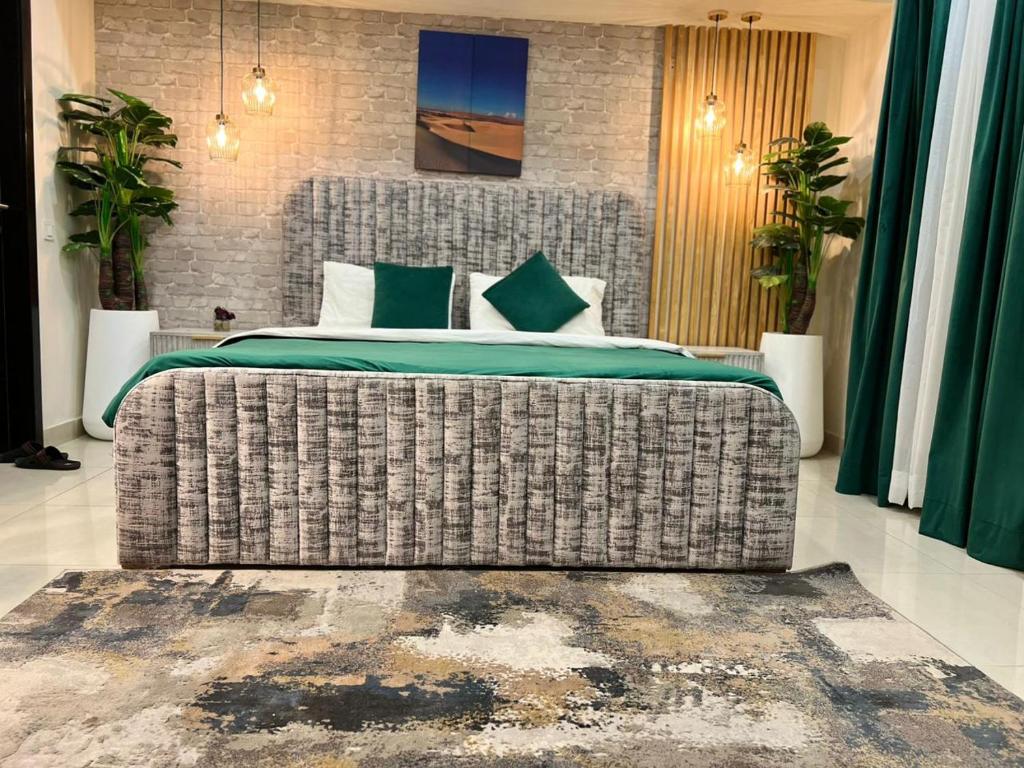 伊斯兰堡Executive Studio Apartment Opposite Centaurus Mall Islamabad的一间卧室配有一张带绿色床单的大床