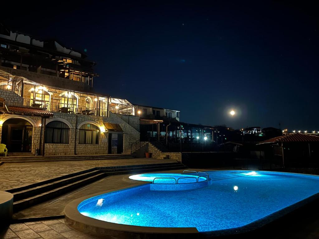 阿巴纳西Complex Bolyarsko selo & Spa的一座大型蓝色游泳池,在晚上在大楼前