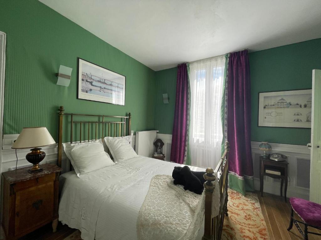 特鲁瓦La Bonne Maison 3的绿色卧室设有床和窗户