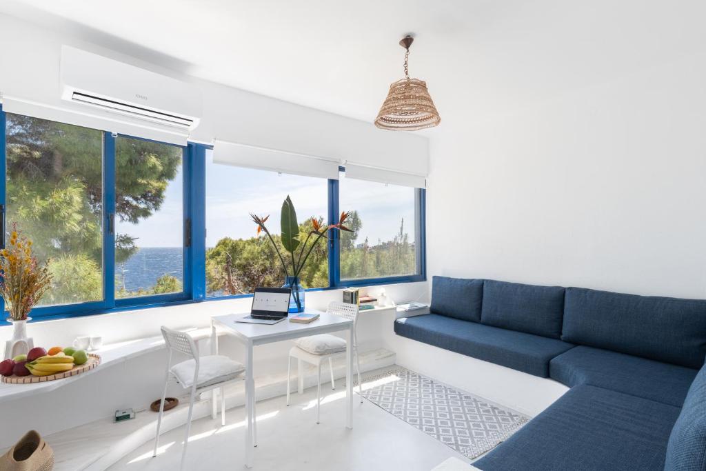 苏尼翁Renovated Seaside Cabin in Sounio的客厅设有蓝色的沙发和窗户。