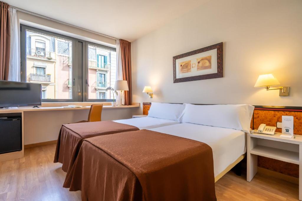 巴塞罗那格洛雷耶斯酒店的配有一张床和一张书桌的酒店客房