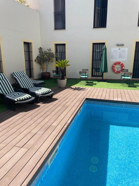 圣玛丽亚港帕拉西奥德卢甲酒店的一座带两把椅子的游泳池位于大楼旁