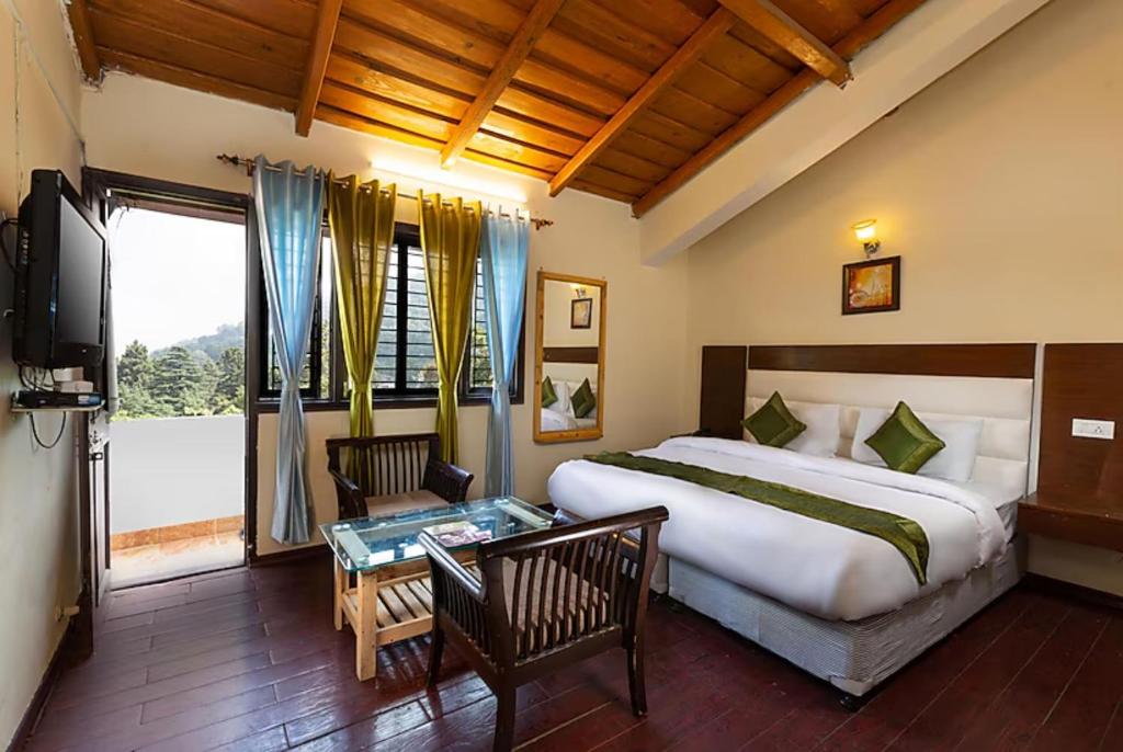 奈尼塔尔Hotel Cottage Orchid Nainital - Parking Facilities - Luxury & Hygiene Room - Best Seller的一间卧室配有一张大床和一台电视。