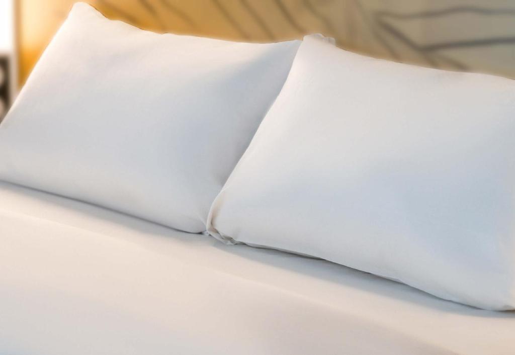 安锡B&B HOTEL Annecy Cran-Gevrier的床上的白色枕头