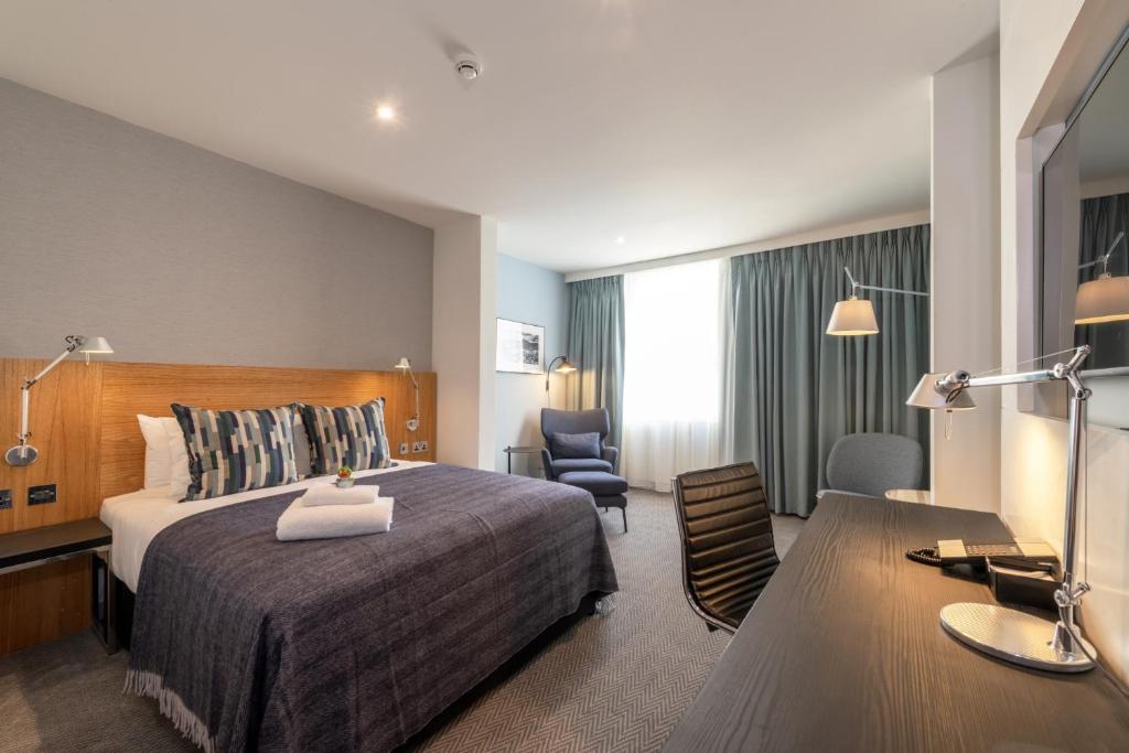 爱丁堡派克斯爱丁堡城市酒店的配有一张床和一张书桌的酒店客房