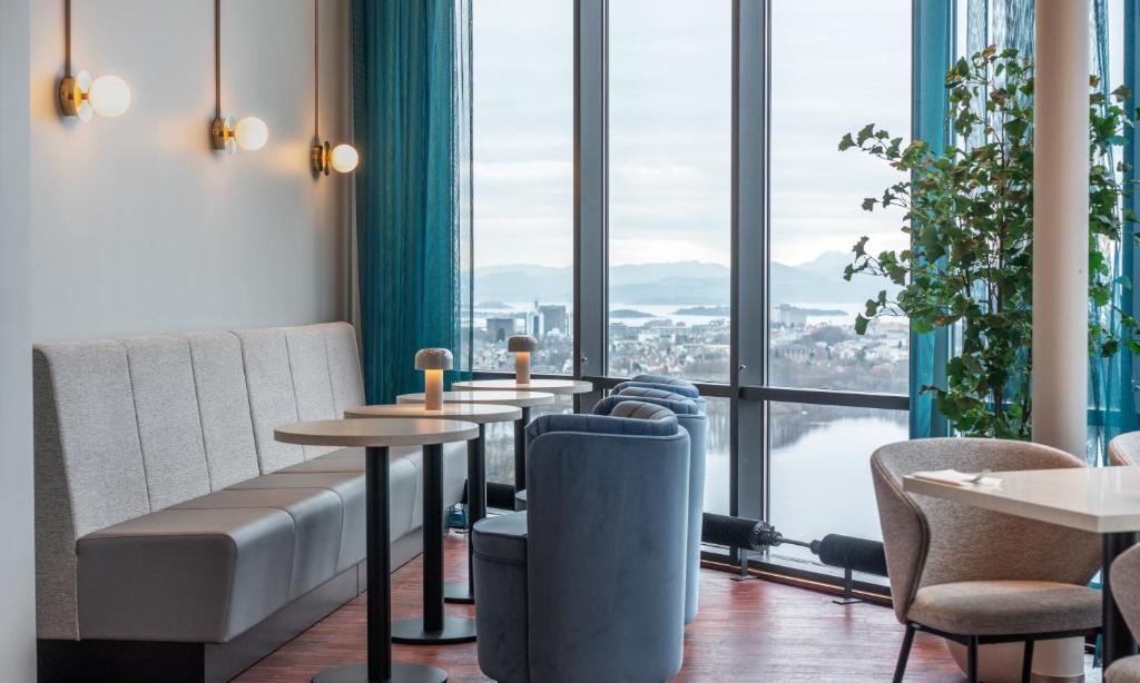 斯塔万格Thon Partner Stavanger Forum Hotel的餐厅设有桌椅和大窗户。