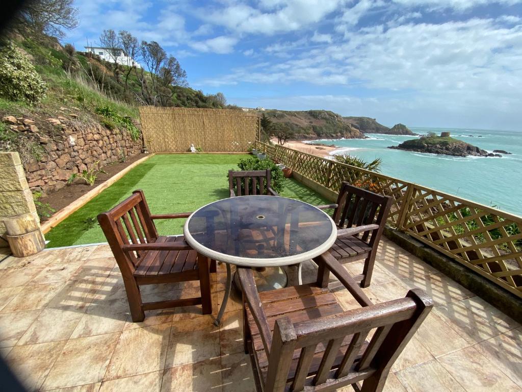 圣布雷拉德Portelet Bay的一个带桌椅的庭院和大海