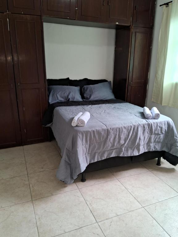 贝洛奥里藏特Casa espaçosa em Belo Horizonte的卧室内的一张带两张拖鞋的床