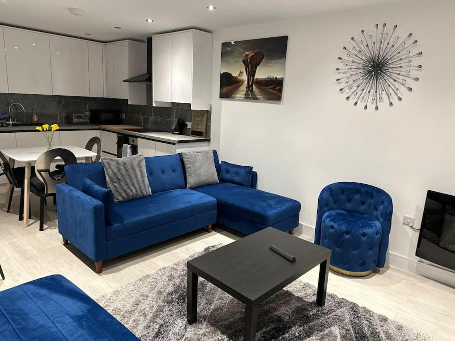 德比KYOTO HOUSE CENTRAL DERBY I SPACIOUS, WARM & NEW with NETFLIX的一间带蓝色沙发的客厅和一间厨房