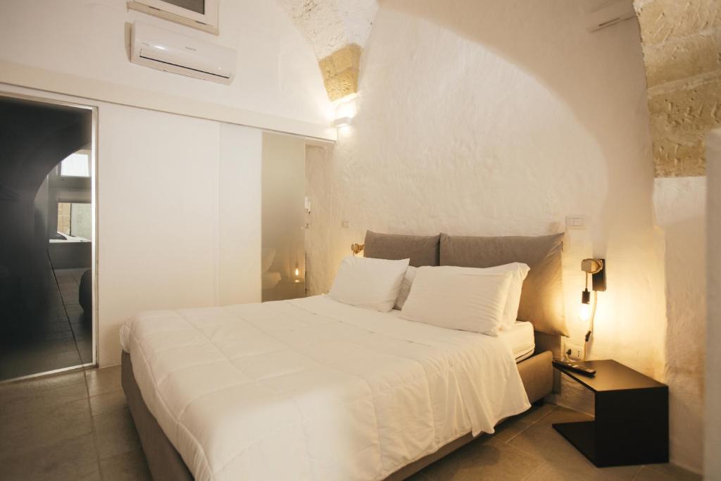 莱切Mediterranee Suite的卧室配有白色大床、白色床单和枕头