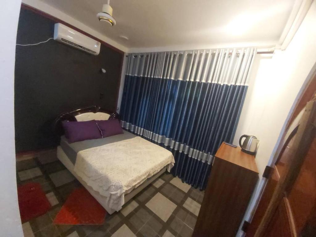 贾夫纳Gabriel Lanka Hotel (PVT) LTD的一间带一张床和淋浴的小卧室