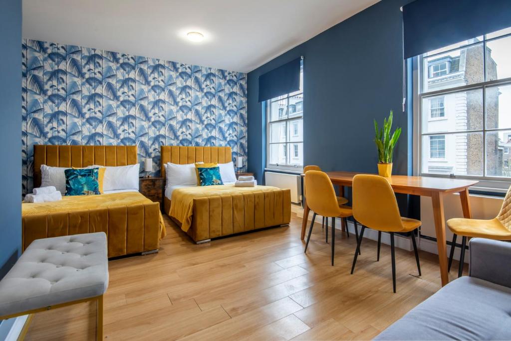 伦敦BRAND NEW The Palms: Luxury Family Residence的一间设有两张床和一张桌子及椅子的房间