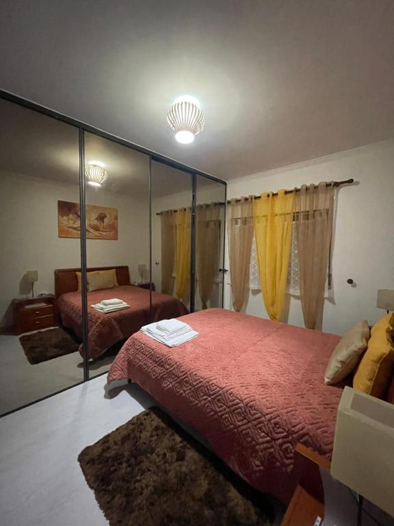阿尔马达Quarto Suite Relaxante的一间卧室配有两张床和镜子