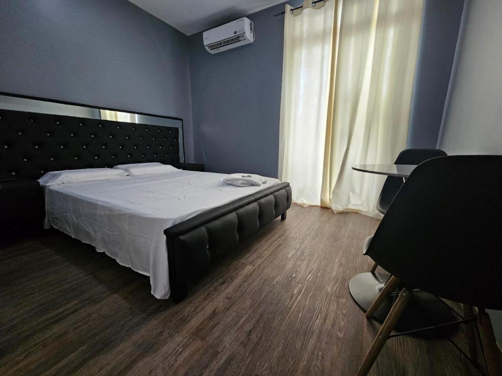 巴拿马城RESIDENCIAL LA MALVARROSA的一间卧室配有一张大床和一张桌子及椅子