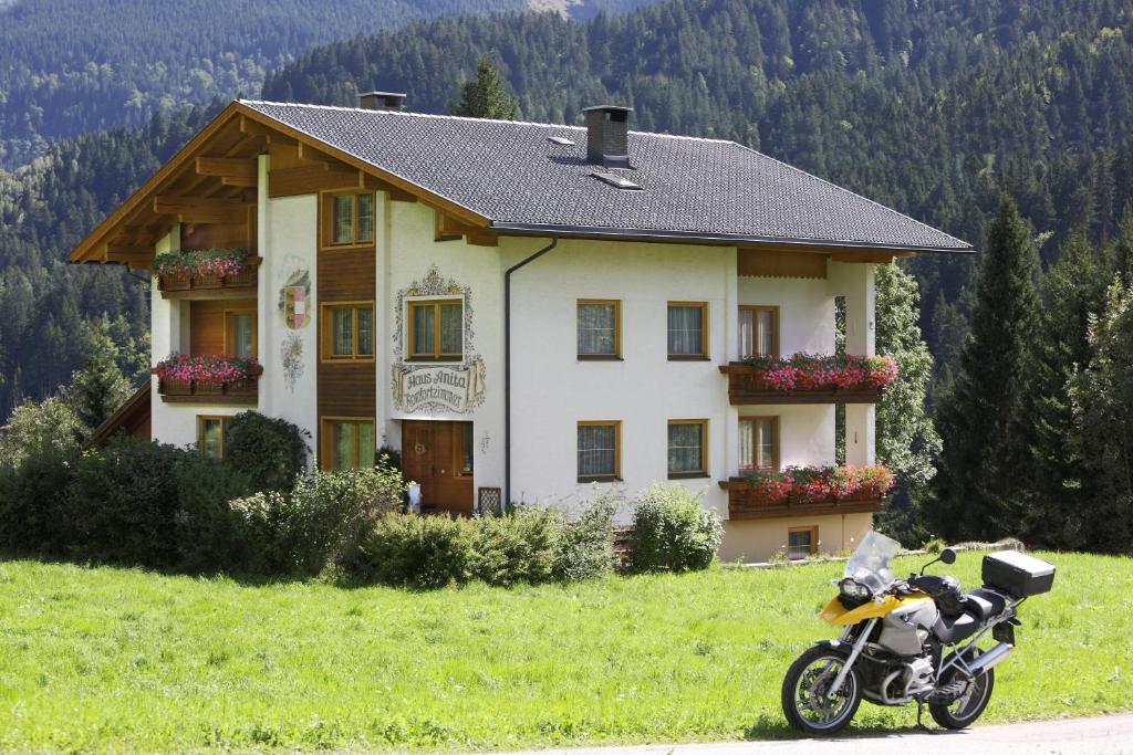 列兴Hotel Garni Haus Anita的停在房子前面的摩托车