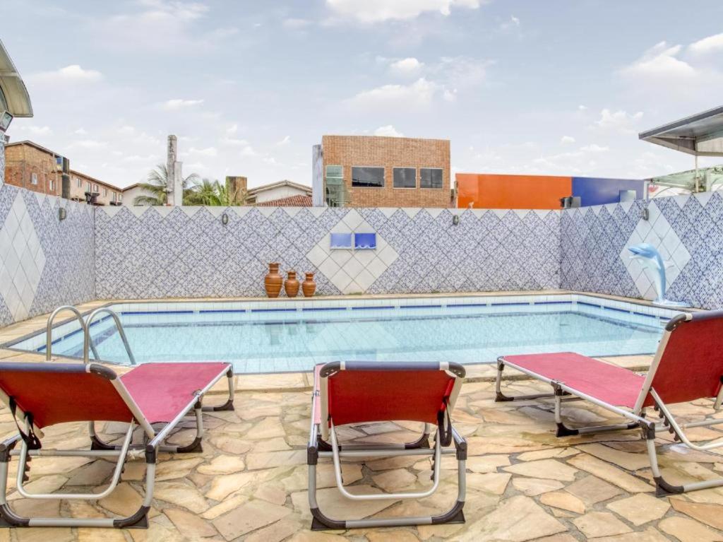 萨尔瓦多Hotel Park Stella Mares的一个带两把椅子和一对的游泳池