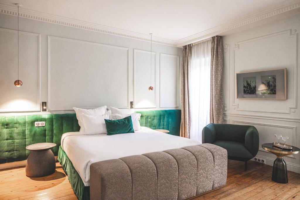 波尔多Hôtel Singulier Bordeaux的配有一张床和一把椅子的酒店客房