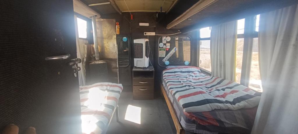 波特雷里约斯BusTel Hostel en Bus的小房间,火车上设有两张床