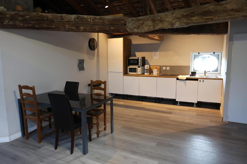 克罗勒Chambres de la ferme du Brocey的厨房以及带桌椅的用餐室。