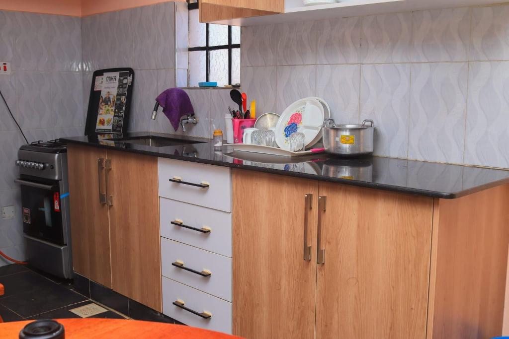 MeruTamwe ltd Airbnb &studios的厨房配有黑色台面和炉灶
