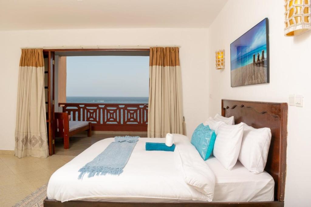 蒙巴萨La Mera Beachfront Apartment的一间卧室设有一张床,享有海景
