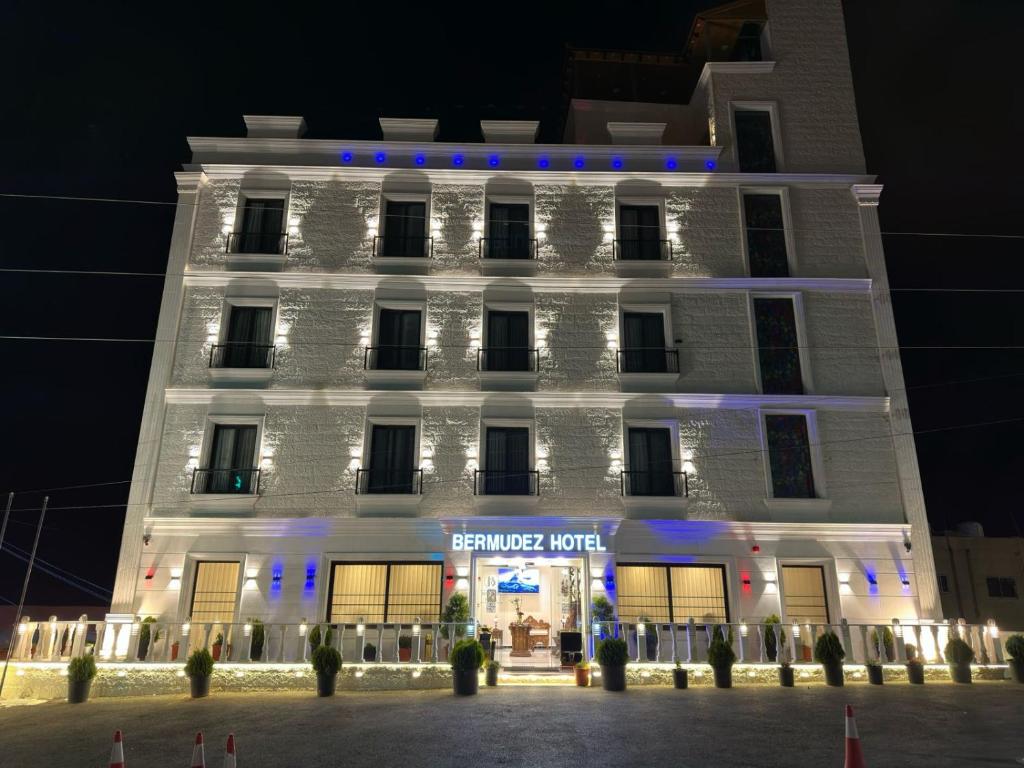 瓦迪穆萨Petra Bermudez Hotel的白色的建筑,有蓝色的灯光