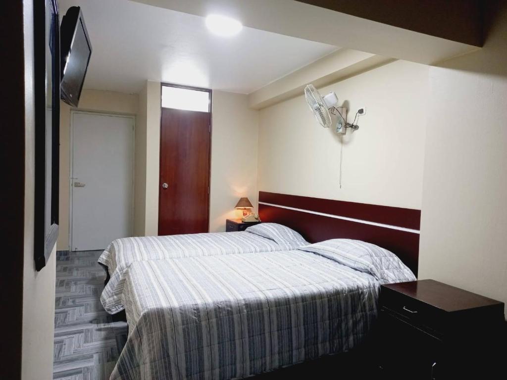 利马Hotel Perú Pacífico的一间卧室配有两张床和电视。