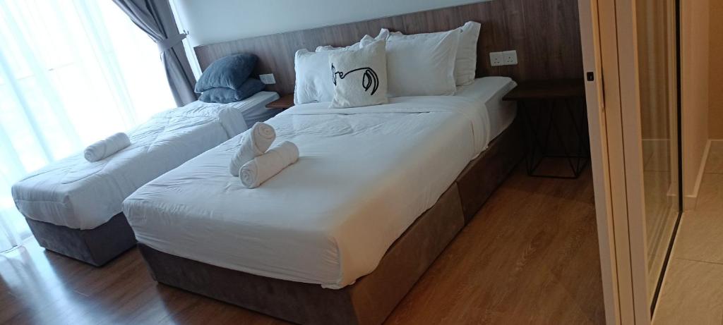 吉隆坡QUILL APARTMENT SKY 1018的两张位于酒店客房的床,配有毛巾