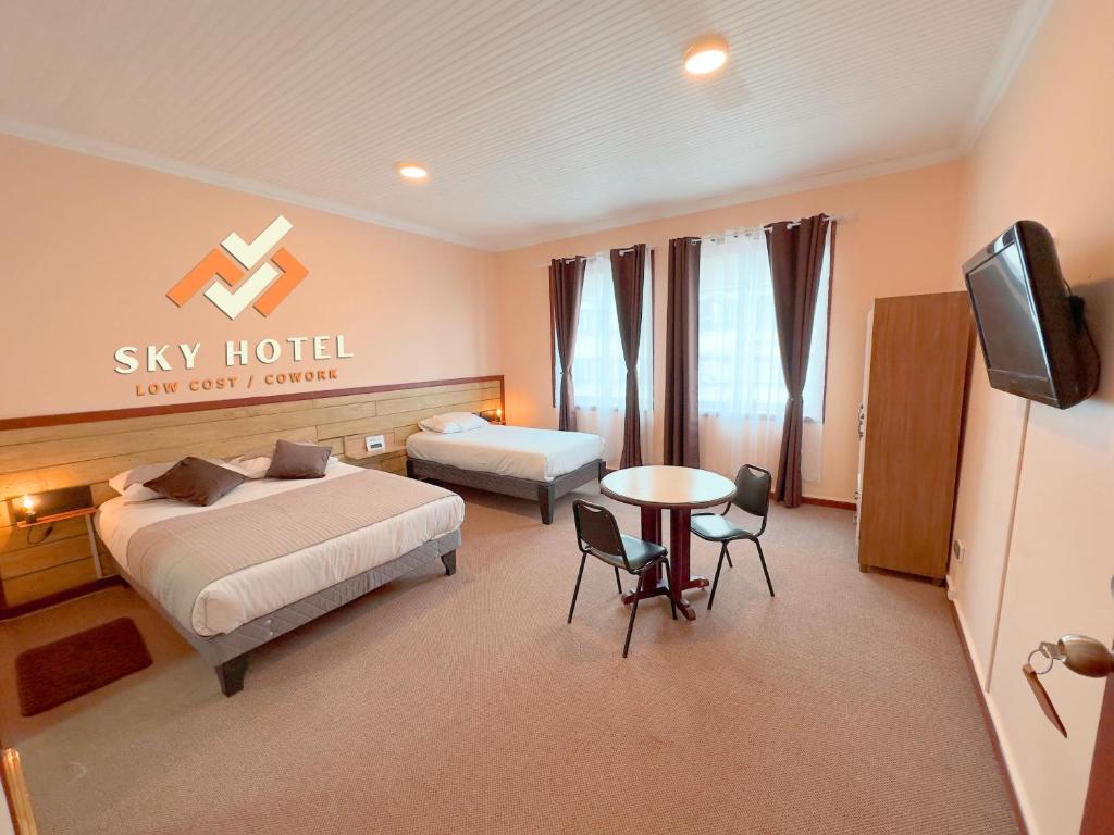 奥索尔诺Sky Osorno的一间卧室设有两张床、一台电视和一张桌子
