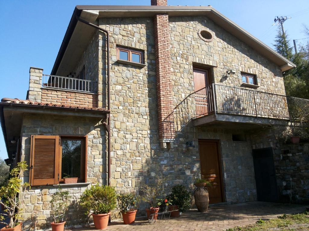 波利卡Agriturismo La Mancosa的带阳台和盆栽植物的石头房子