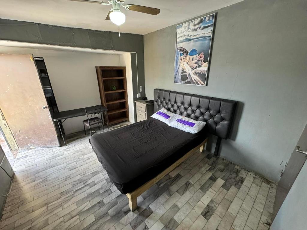 华雷斯城Loft economico cerca del puente Santa Fe的一间位于客房内的带黑色床的卧室