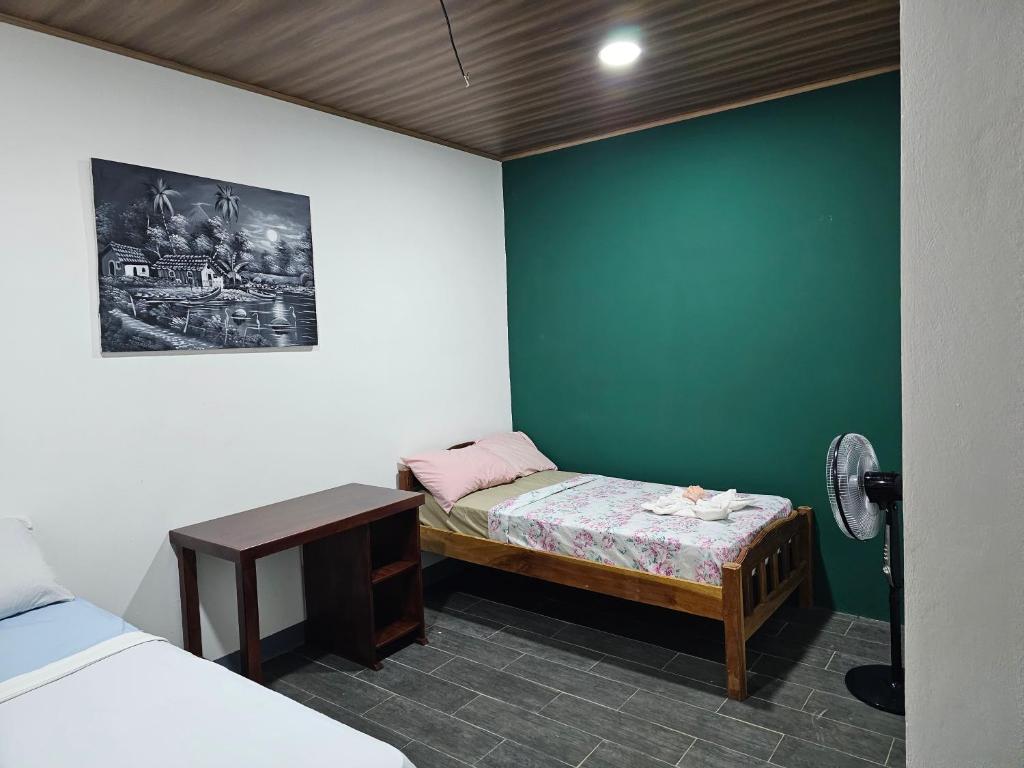 莫约加尔帕Hostal Mamá Derlys的客房设有一张小床和一张小桌子。