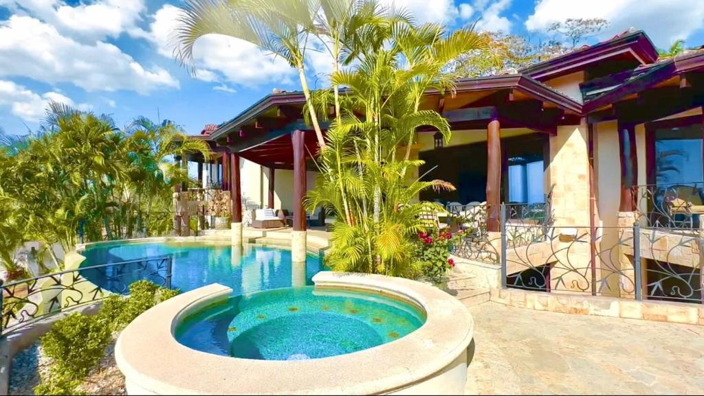 瓜纳卡斯特Villa Durazno的房屋前有游泳池的房子