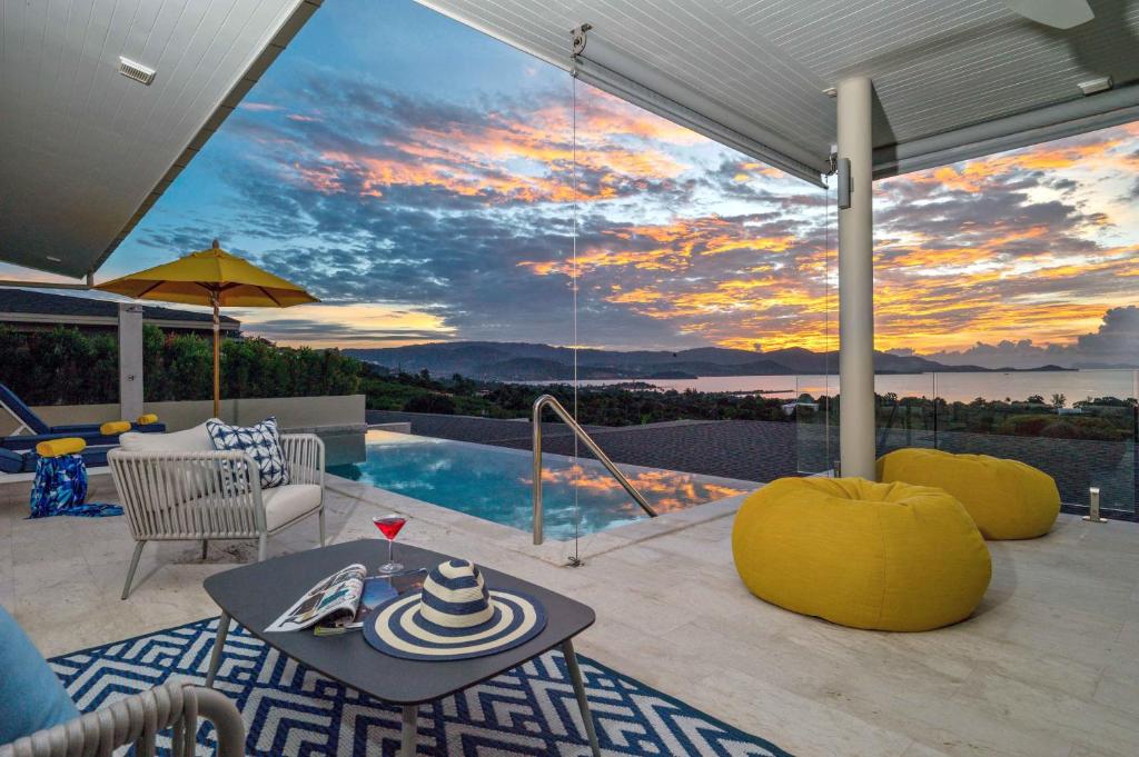 曾蒙海滩Sunset Estates - Samui Luxury Villas的一个带桌子的庭院和一个享有日落美景的游泳池