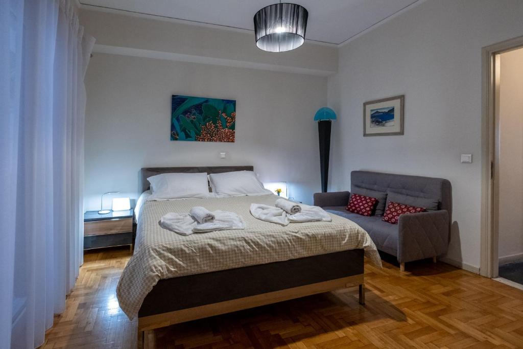 雅典Oro's Stylish Kolonaki Flats Next to Metro & Museums的一间卧室配有一张床和一张沙发