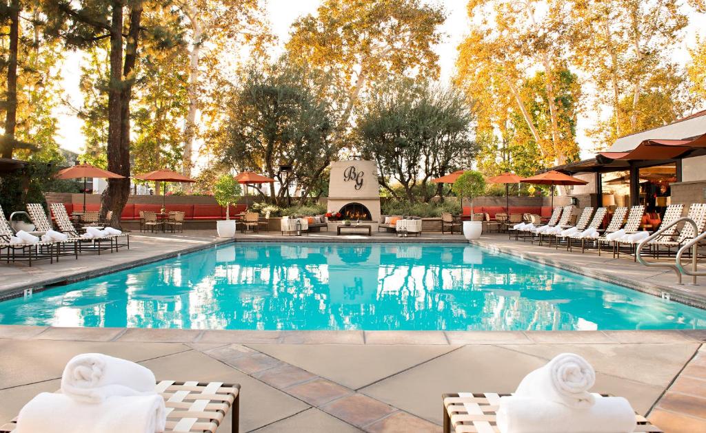 洛杉矶加兰酒店的一座带椅子和壁炉的游泳池