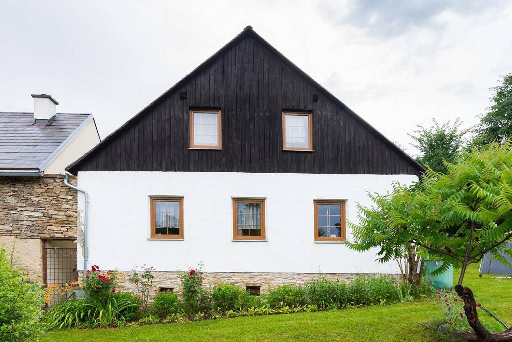 KlenovicePoklidná Chalupa的黑色屋顶的大型白色房屋