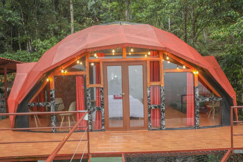 明多GLAMPING MINDO SUYANA的甲板上带红色屋顶的圆屋