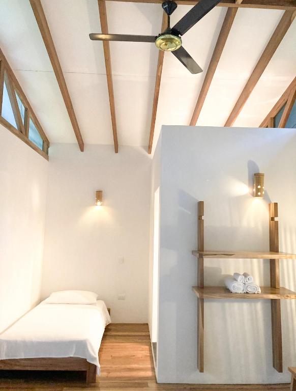 福尔图纳Casa Yami Lodge的带床和吊扇的卧室