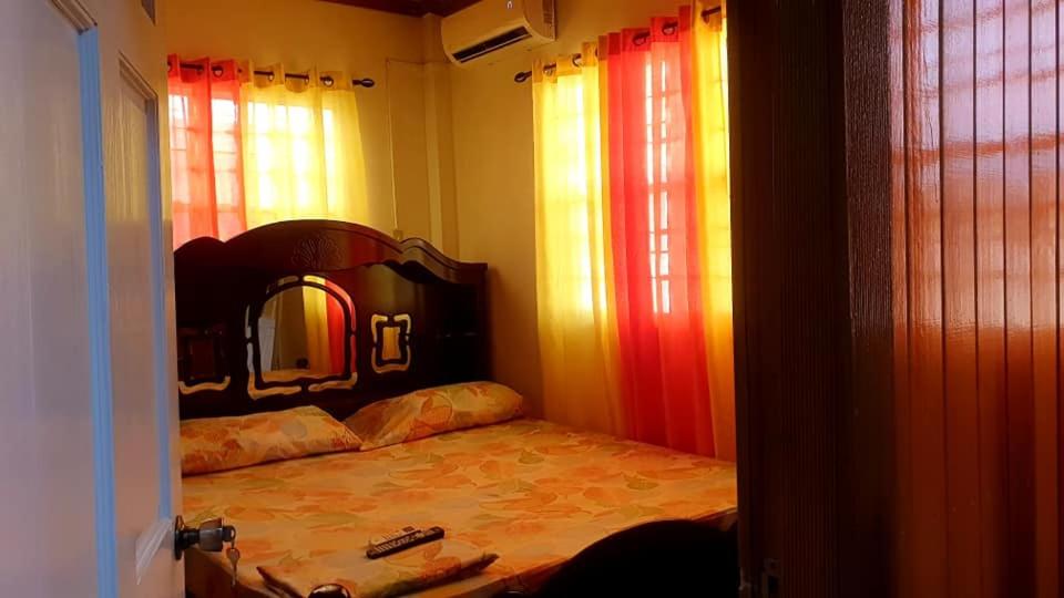 乔治敦S&S Guyana Real Estate Apartment的一间卧室配有一张带镜子和窗户的床