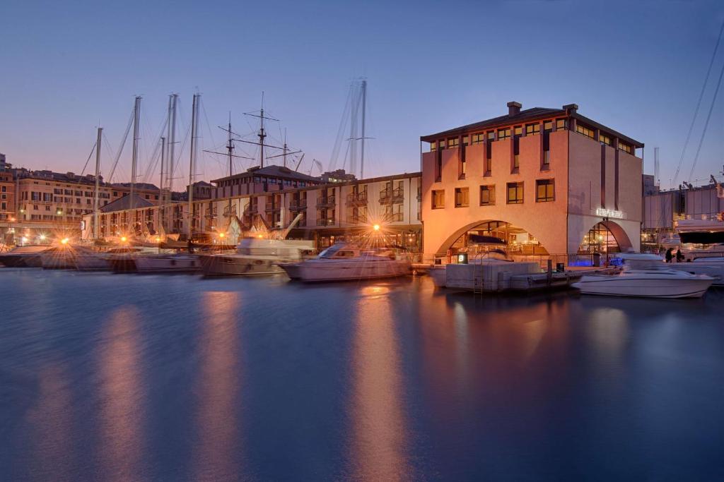 热那亚热那亚码头NH典藏酒店的一群船在晚上停靠在码头