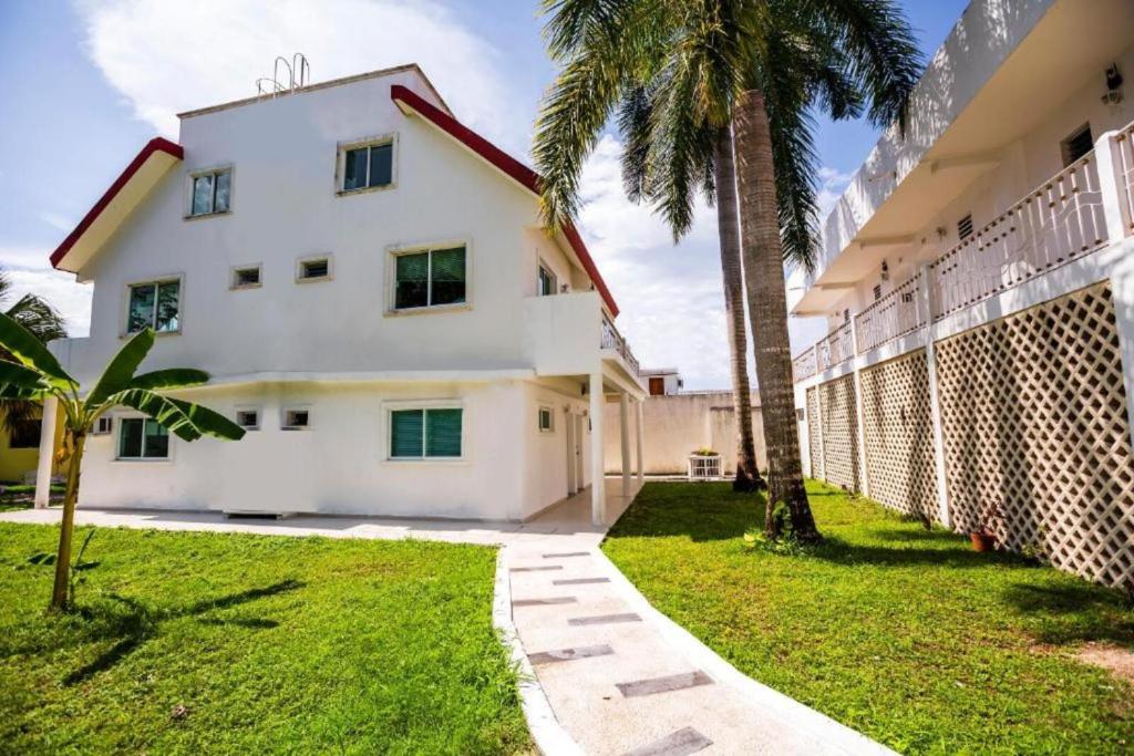 科苏梅尔Hotel Dos Mundos, Isla Cozumel的院子里有棕榈树的白色房子