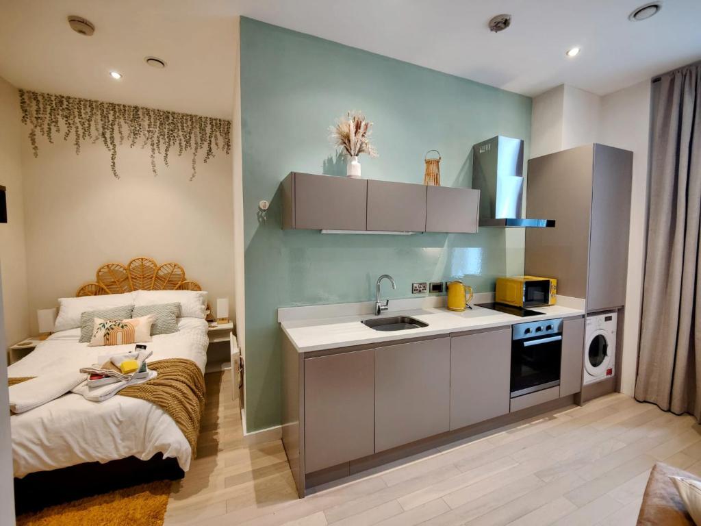 利物浦Liverpool Gem: Cozy Studio Retreat的一个带水槽的小厨房和一张位于客房内的床