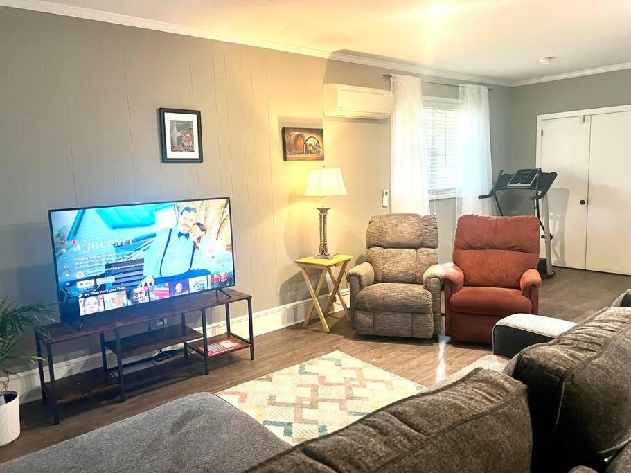 阿森斯The Cozy Place的客厅配有平面电视和椅子