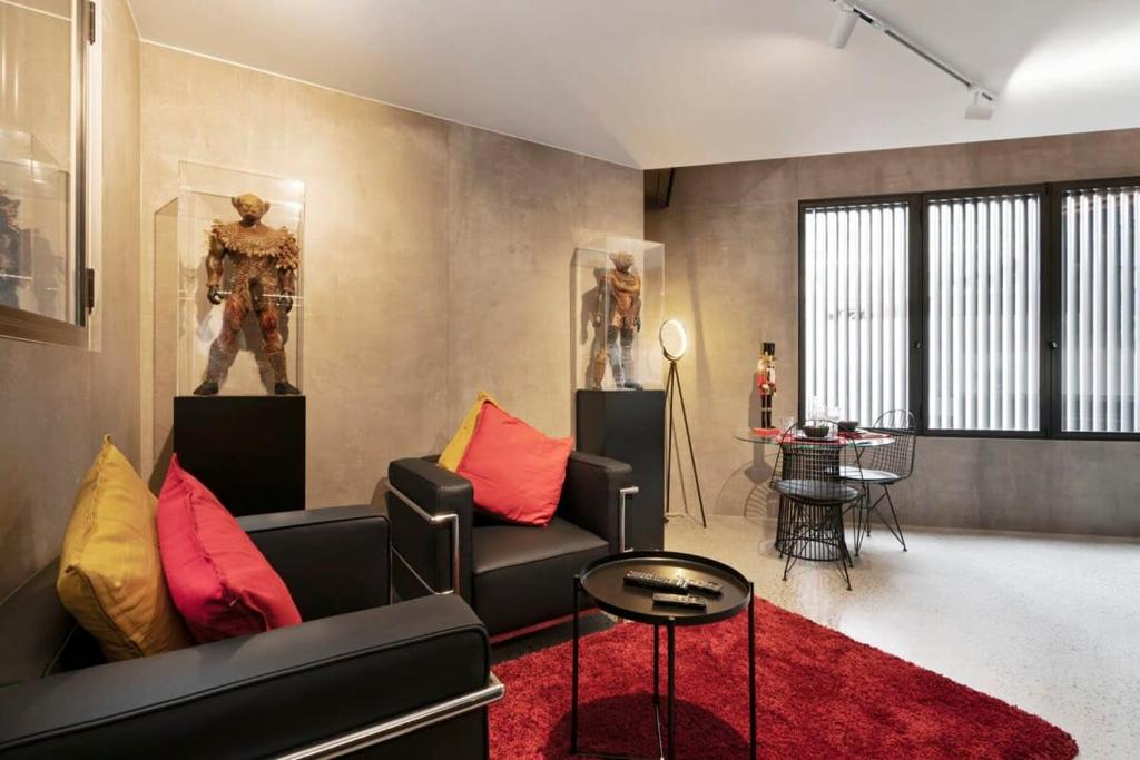 悉尼New York style Loft的客厅配有黑色沙发和红色地毯。