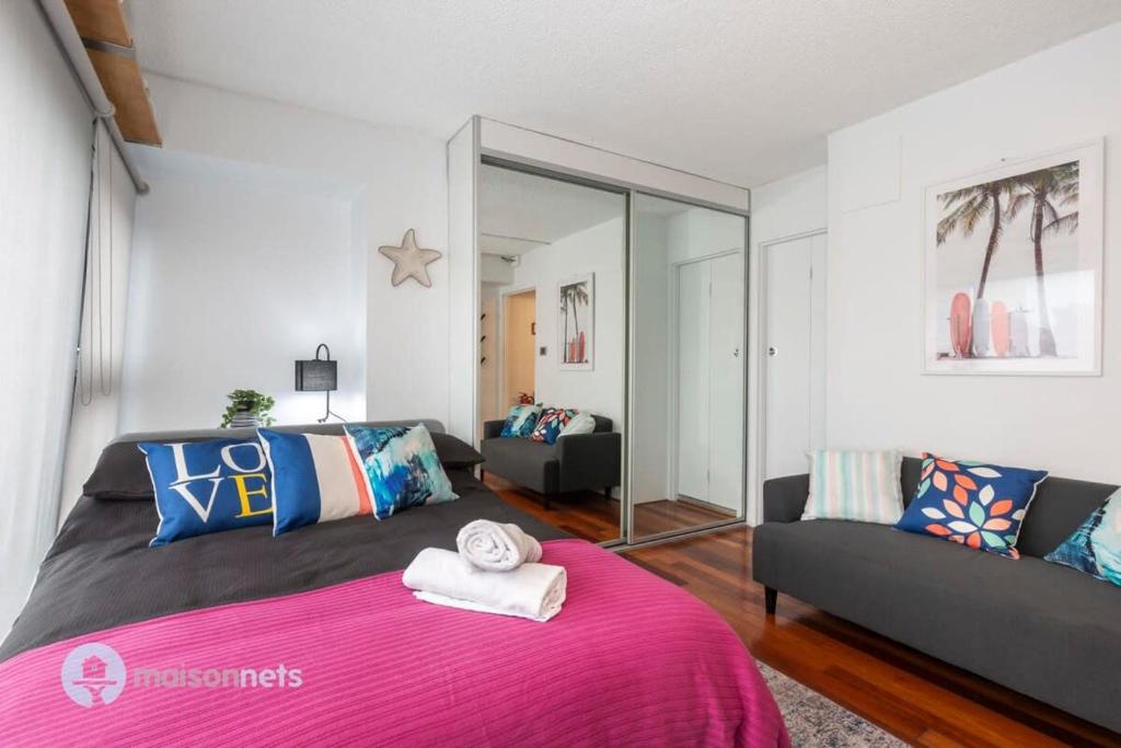悉尼Studio Gem With Rooftop Space Prime Location的卧室配有粉红色的床和沙发