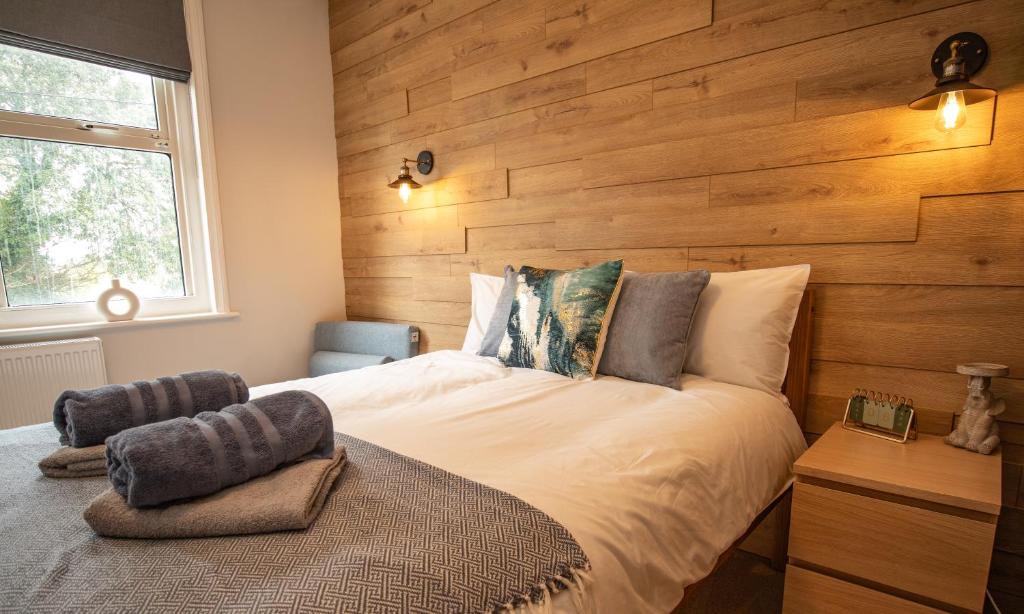 伊斯特布恩Aqua nest Eastbourne的一间卧室设有一张带木墙的大床