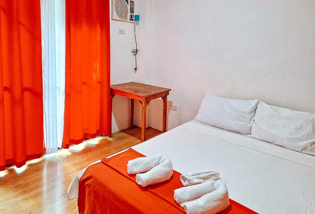 卢纳将军城RedDoorz @ Hergem Siargao Inn的一间卧室配有带毛巾的床