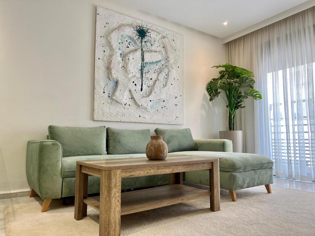 卡萨布兰卡Maârif Cosy Apartment - Dynasty Estate的客厅配有绿色沙发和桌子