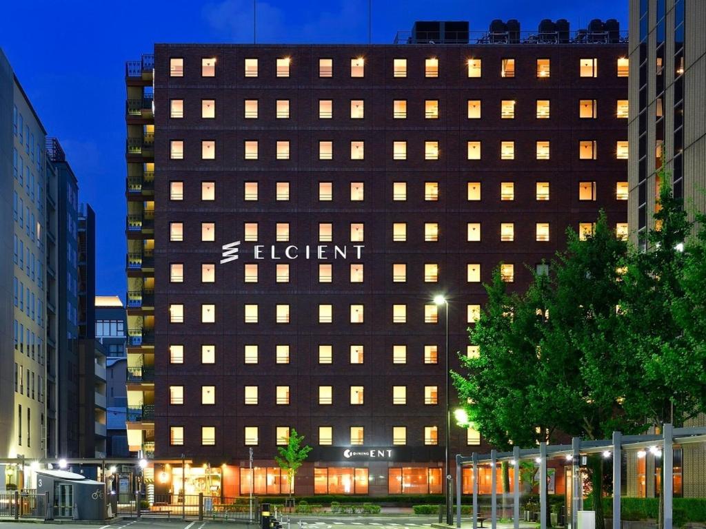 京都Hotel Elcient Kyoto Hachijoguchi的棕色的建筑,旁边标有标志